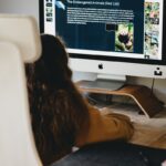 woman in black shirt sitting in front of silver imac