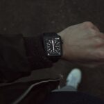 person wearing space black Apple Watch with black strap