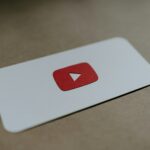 a red and white play button on a white card