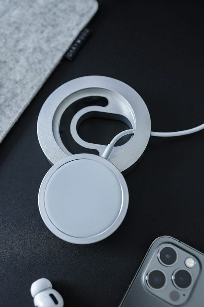 Wireless charging pad white round plastic frame on black table