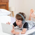 girl in gray t-shirt using white laptop computer