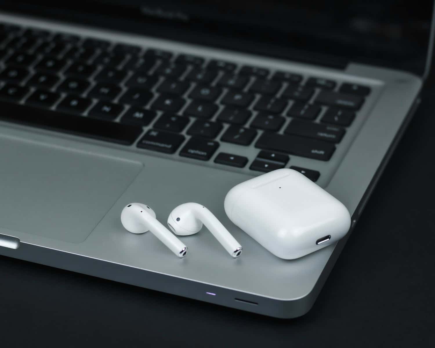 white apple airpods on macbook pro